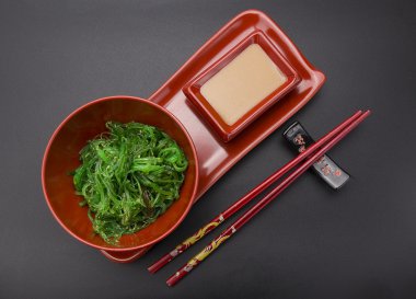 Siyah arka plan üzerinde fındık soslu chuka salatası