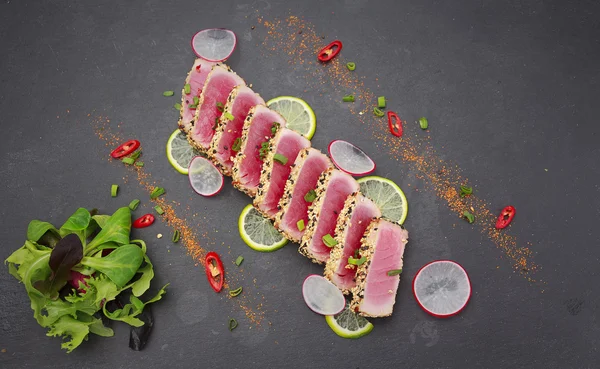 Філе тунця з кунжутом, прикрашеним лимоном та овочами — стокове фото