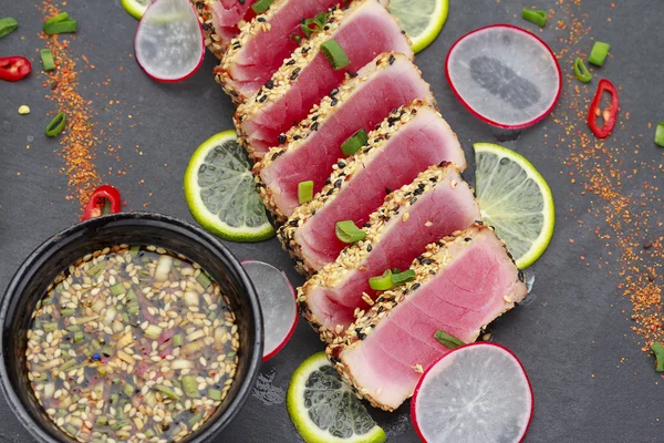 Філе тунця з кунжутом, прикрашеним лимоном та овочами — стокове фото