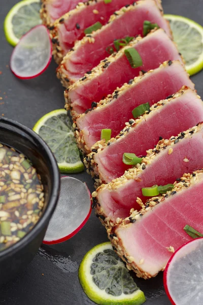 Tonijn filet met sesam versierd met limon en groenten — Stockfoto