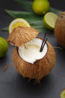 Hindistan cevizi kokteyl limon ve kivi ile siyah bir tabloda.