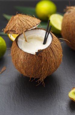Hindistan cevizi kokteyl limon ve kivi ile siyah bir tabloda.