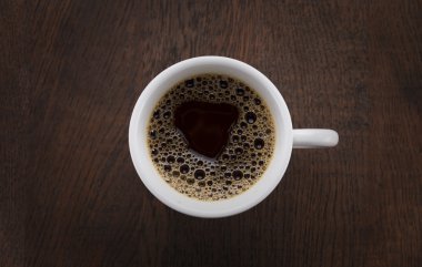 Kahve fincanı. Kahve çekirdekleri ve ahşap bir masa çikolata