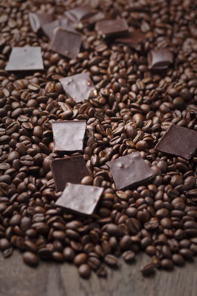 Grãos de café com chocolate em fundo de madeira — Fotografia de Stock