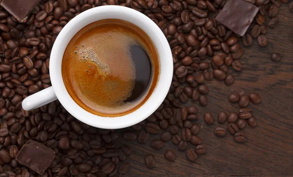 Café. Granos de café y chocolate en una mesa de madera — Foto de Stock