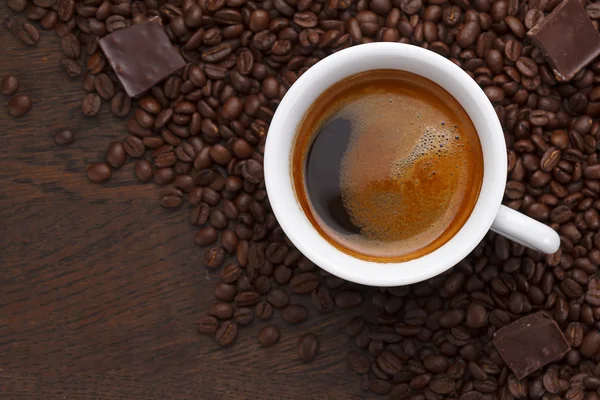 Café. Granos de café y chocolate en una mesa de madera — Foto de Stock