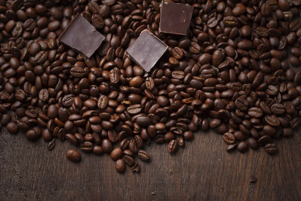 Grãos de café com chocolate em fundo de madeira — Fotografia de Stock