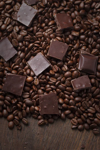 Grains de café avec du chocolat sur fond en bois — Photo