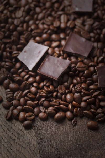 Grains de café avec du chocolat sur fond en bois — Photo