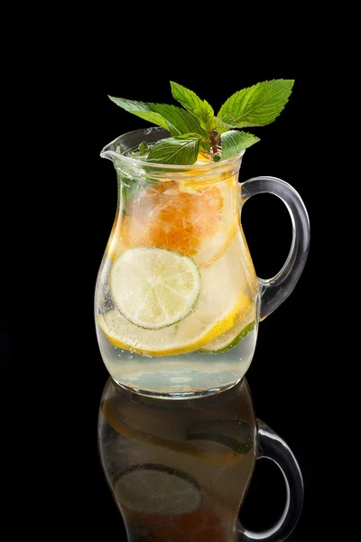 Brocca di limonata con limone lime arancione e menta su sfondo nero — Foto Stock