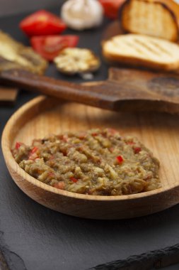 Karanlık tablo üzerinde ahşap rustik tabakta Egplant havyar (salata)