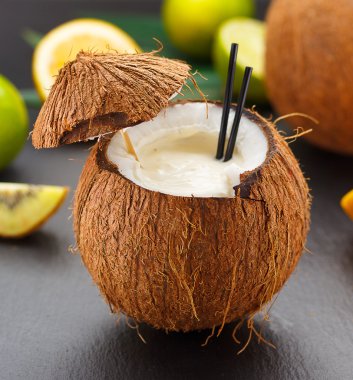 Hindistan cevizi kivi, portakal ve limon ile siyah bir tabloda kokteyl.