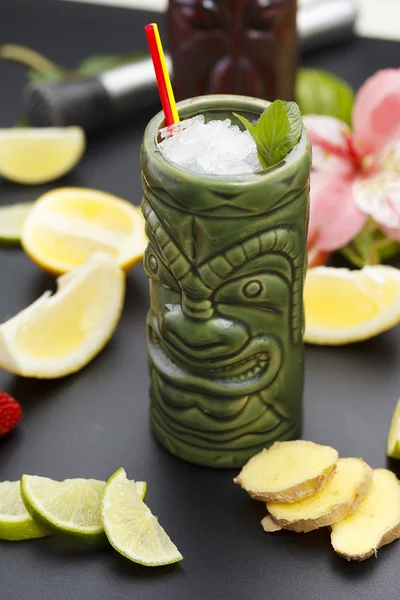 Tropische cocktails geserveerd in een glas tiki stijl en gegarneerd met fruit en ijs — Stockfoto