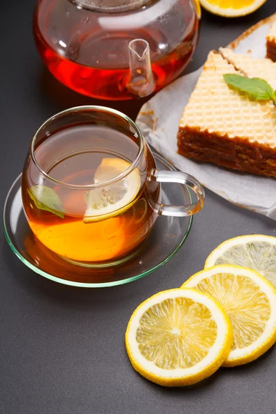 練乳と黒いテーブルに新鮮な熱い紅茶と甘いワッフル三角ケーキ — ストック写真