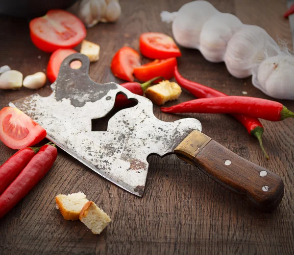 Свежие помидоры, гарлик и старый нож на деревянном столе — стоковое фото
