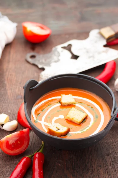 Tomatsoppa med krutonger chilipeppar och garlik på ett träbord — Stockfoto