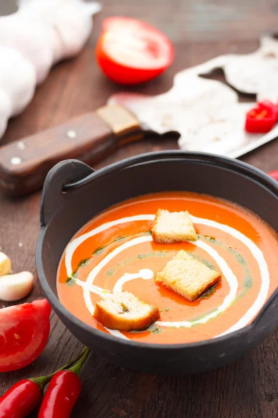 Tomatsoppa med krutonger chilipeppar och garlik på ett träbord — Stockfoto