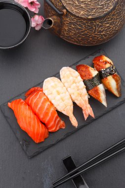 Suşi nigiri taş bir plaka üzerinde siyah arka plan üzerinde ayarla