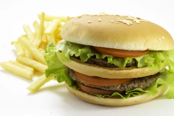 Grote en smakelijke hamburger en gebakken aardappelen geïsoleerd op witte achtergrond — Stockfoto