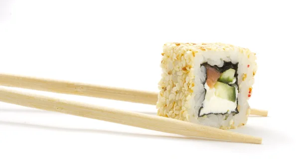 Rouleau de sushi au saumon et sésame sur baguettes isolées sur fond blanc — Photo