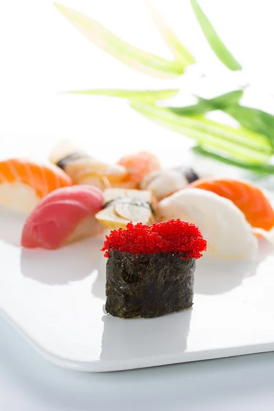 Sushi gunkan con tobiko negro y nigiri en un plato blanco — Foto de Stock