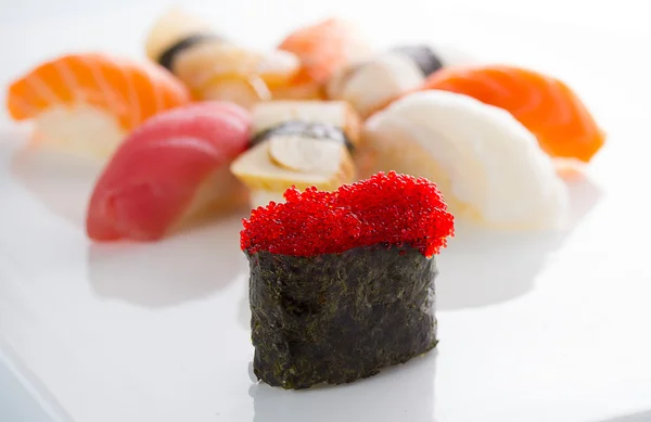 Gunkan sushi z czarnym "Tobiko" i nigiri na białym talerzu — Zdjęcie stockowe