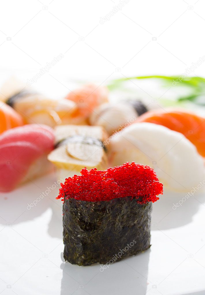 Sushi gunkan with red tobiko and nigiri on a white plate