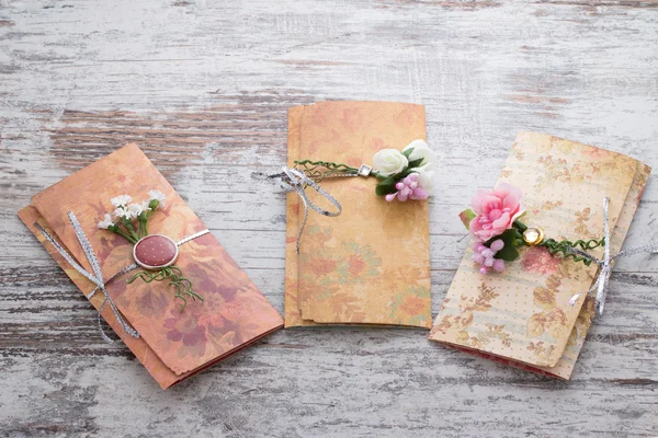 Handgemaakte huwelijksuitnodigingen gemaakt van papier pver houten vintage backgroundd — Stockfoto