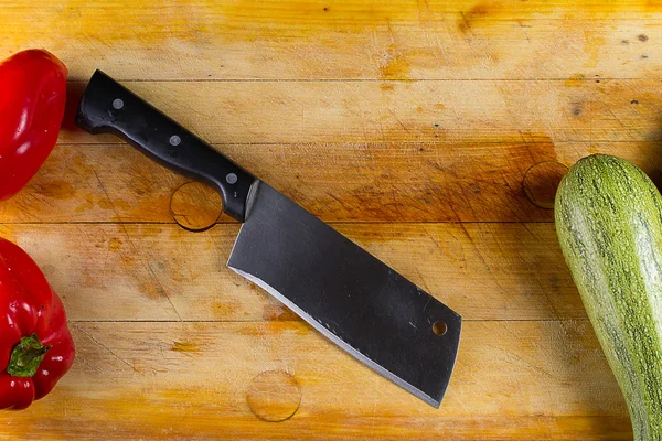 Poivron rouge et moelle de légumes avec couteau sur une planche de bois — Photo