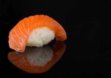 Somon suşi nigiri yansıması ile siyah arka plan üzerinde