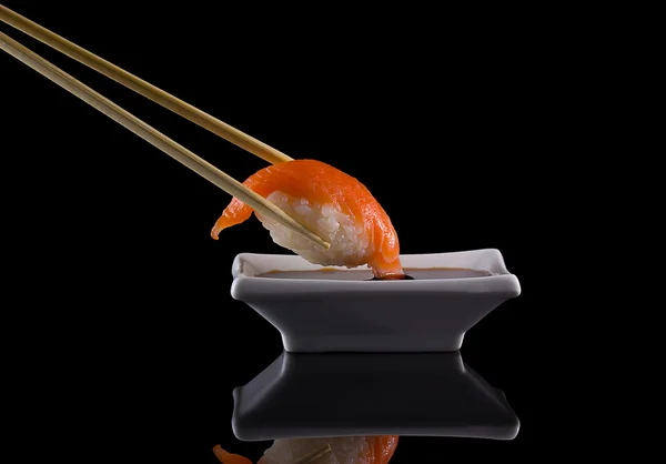 Salmão sushi nigiri sobre fundo preto com reflexão — Fotografia de Stock