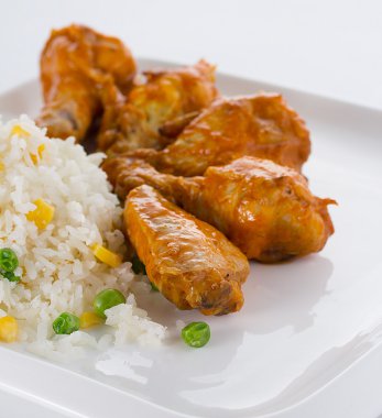 Beyaz tabakta pilavlı köri tavuk