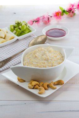 Kivi ve muz üzerinde ahşap antika arka plan ile yulaf lapası