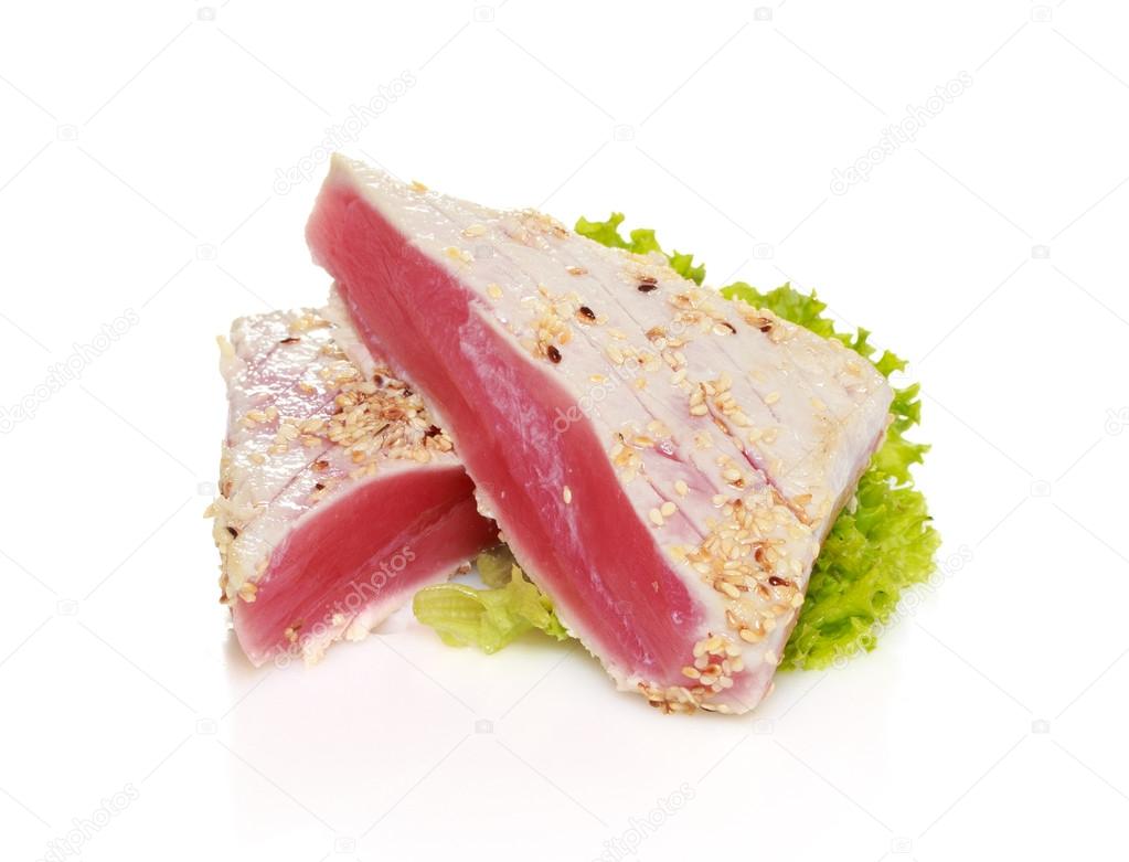 Piece of tuna fillet with sesame and fresh green salad isolated on white background