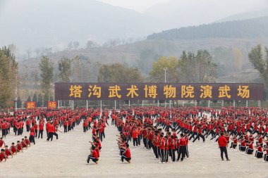 Dengfeng, Zhengzhou, Henan, Çin - 16 Ekim 2018: Meydanda büyük bir grup dövüş sanatları öğrencisi eğitim görüyor. Shaolin Dövüş Sanatları Okulu.