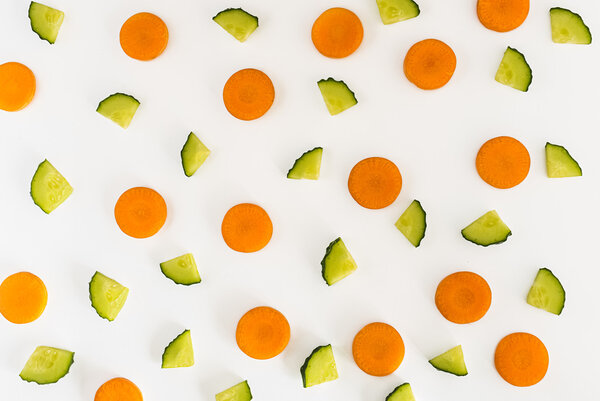 cucumbers and carrot slices on white background. Top view, Flat lay.
