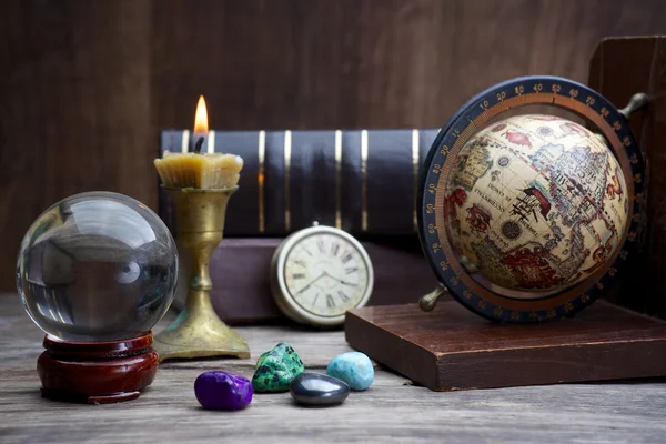 Astrologie antică. Vechi glob astrologic și cărți cu lumânare aprinsă — Fotografie, imagine de stoc