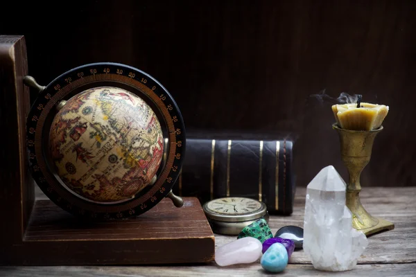 Ancient astrology. Old astrology globe and books with candle — Stock Photo, Image