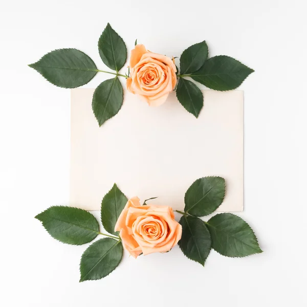 Cadre décoratif avec des roses orange et des feuilles vertes. Pose plate. Vue du dessus — Photo