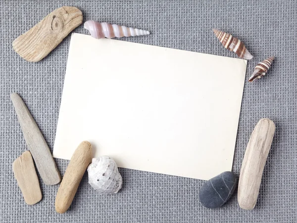 Hintergrund mit Muscheln und Holzstäben, die einen Rahmen für jeden Text bilden. Ansicht von oben — Stockfoto