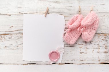pembe bebek booties. Beyaz ahşap arka plan üzerinde balmumu mühür ile küçük kız çorap ve boş kart