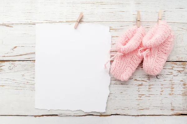 Roze babys laarsjes. Kleine meisjes Sok en blanco kaart op witte houten achtergrond — Stockfoto