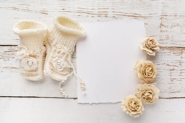 Recién Nacido o Bautismo Tarjeta de felicitación. Zapatos y guantes en blanco con bebé niña sobre fondo de madera blanco —  Fotos de Stock