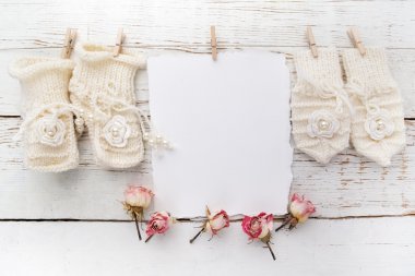 Yeni tarihi veya vaftiz tebrik kartı boş bebek kız ayakkabı ve eldiven Beyaz ahşap zemin üzerinde