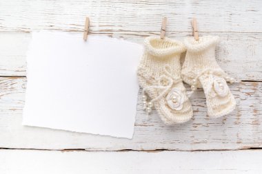 Yeni Doğan veya vaftiz Tebrik Kartı. Beyaz ahşap arka plan üzerinde bebek kız ayakkabıları ile Boş