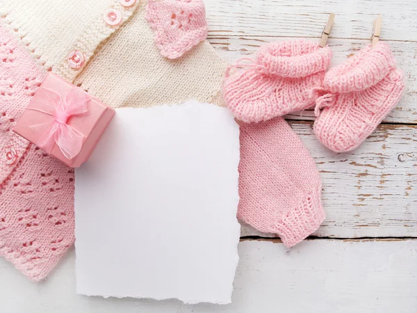 Baby meisje kleren met blanco kaart op witte houten achtergrond. Platte lag. Owerhad uitzicht — Stockfoto