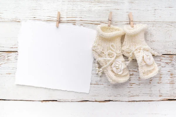 Carte de vœux Nouveau-né ou baptême. Blanc avec des chaussures de bébé fille sur fond blanc en bois — Photo