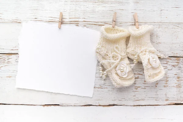 Recién Nacido o Bautismo Tarjeta de felicitación. Zapatos en blanco con bebé niña sobre fondo de madera blanco —  Fotos de Stock