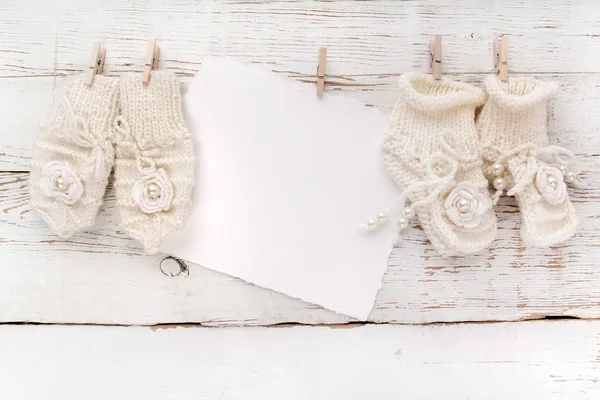 Recién Nacido o Bautismo Tarjeta de felicitación. Zapatos y guantes en blanco con bebé niña sobre fondo de madera blanco —  Fotos de Stock