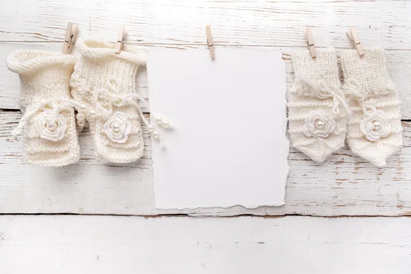 Carte de vœux Nouveau-né ou baptême. Blanc avec des chaussures de bébé fille et des gants sur fond blanc en bois — Photo